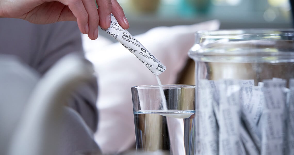 Woman taking one sachet of The Solution from a glass jar
